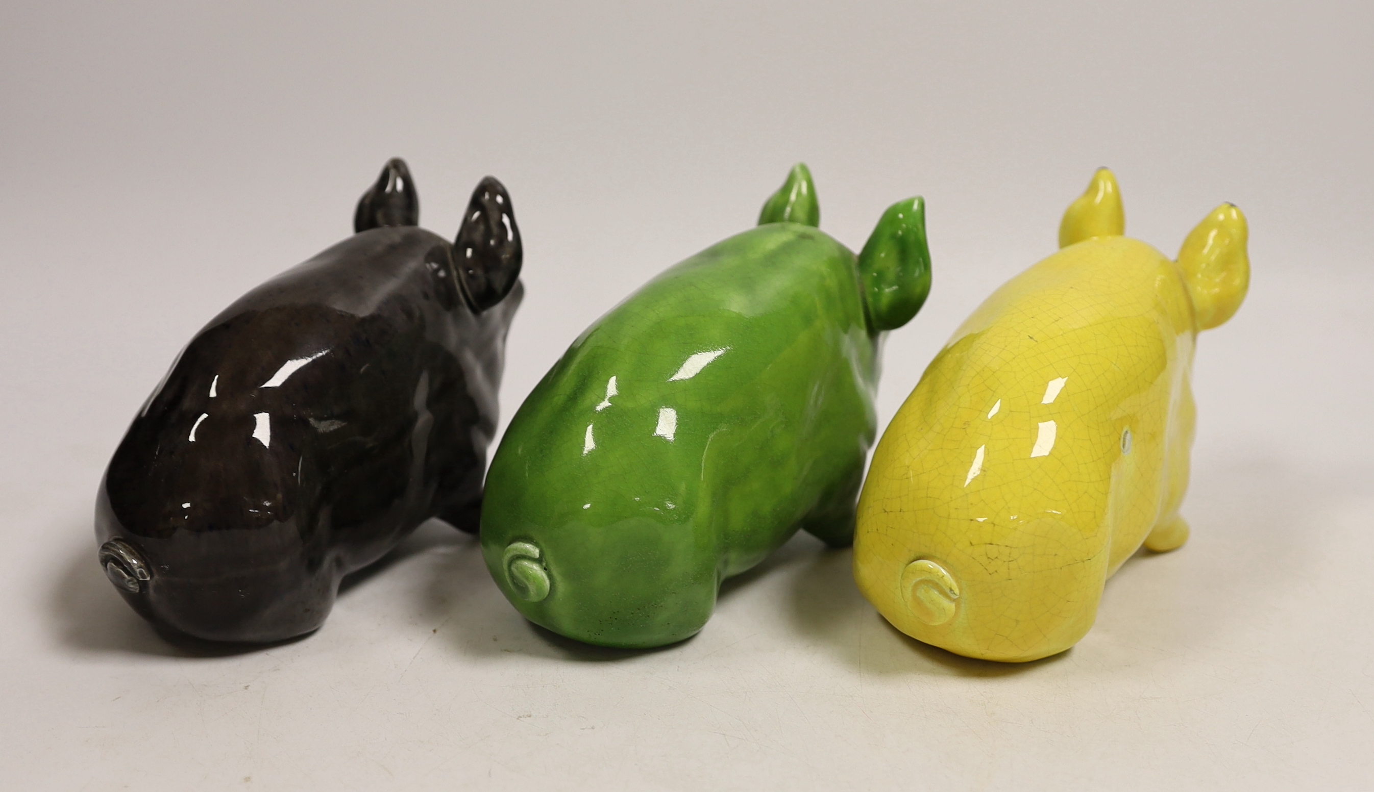 Three Wemyss ware pigs in green, yellow and black glazes, 15cm